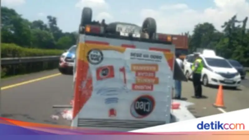 Mobil Boks Pengangkut Air Mineral Terbalik di Tol Jagorawi Akibat Pecah Ban